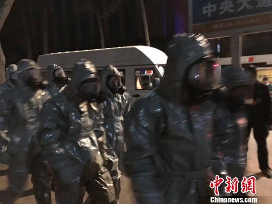 十几名身着防护服的人员头戴面具进入事发地。　胡健 摄